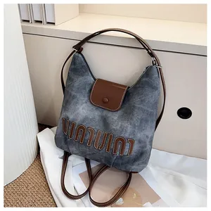 Detailansicht der Canvas-Schultertasche mit braunem Lederbesatz und Magnetverschluss