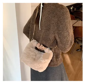 Plüsch-Handtasche in Beige mit gerafftem Ledergriff und goldener Kette in Lifestyle-Szene