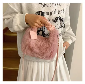 Detail einer weichen rosa Plüschhandtasche mit gerafftem Satingriff und Umhängeriemen