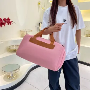 Pink large fitness bag with wet dry separation and brown straps for sports travel
