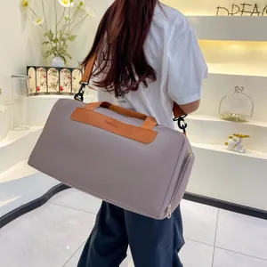 Close-up of gray travel bag featuring premium brown leather handles and a side zipper pocket