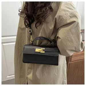 Gros plan du sac en cuir noir texturé avec un fermoir rotatif en métal doré brillant