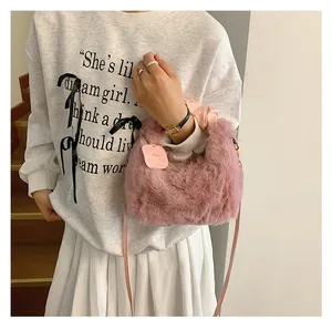 Detailansicht der rosa Plüschhandtasche mit Kunstfell-Textur und Herzanhänger-Charme
