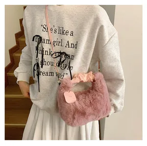 Detail der rosa Plüschhandtasche mit Kunstfell-Textur und gerafftem Griff am Modell