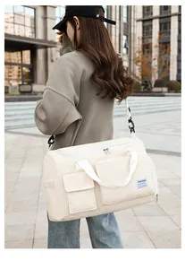 Detail of off-white corduroy duffel bag featuring multiple pockets and fashion label
