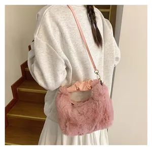 Detailansicht der flauschigen rosa Plüschtasche mit Faltenstiel und Metallhaken im Fokus