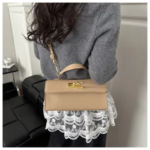 Détail du mini sac Kelly en cuir croisé avec fermoir doré et bandoulière réglable