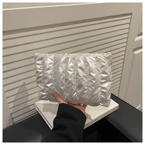 Close-up of a quilted white pearlescent envelope clutch with elegant pleated texture