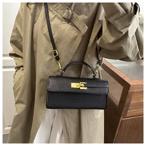 Détail du mini sac bandoulière en cuir noir avec boucle dorée et poignée ronde