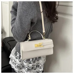 Détails du mini sac style Kelly en cuir blanc avec fermoir métallique doré chic
