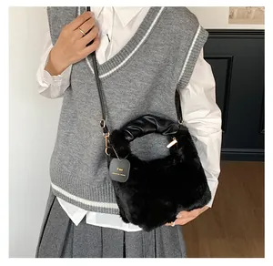 Detail der schwarzen Pelzhandtasche mit gerafftem Ledergriff und abnehmbarem Gurt