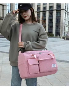 Detailed view of pink corduroy travel bag featuring front pockets and adjustable strap