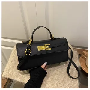 Détail du mini sac à main en cuir grainé noir avec fermoir rotatif doré et poignée