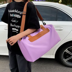 Detailed side view of large lilac gym bag with brown leather handles and shoulder strap