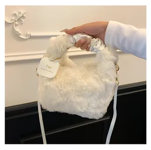 Nahaufnahme der weißen Kunstpelz-Handtasche mit gerafftem Griff und goldenen Metallteilen
