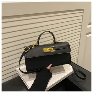 Gros plan d'un sac à main noir en cuir croisé avec fermoir rotatif doré et poignée