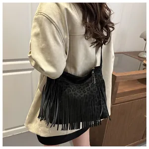 Detail shot of black faux suede tote bag featuring long fringe and subtle leopard pattern