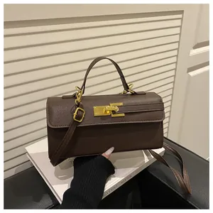 Détail du sac à main en cuir marron avec fermoir métallique doré et bandoulière