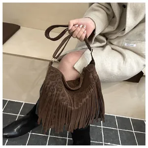 Detail of vintage brown suede tote bag with leopard print side and tassel accents