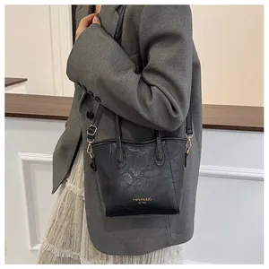 Close-up of black textured leather bucket bag featuring gold Fashion & BaG printed text