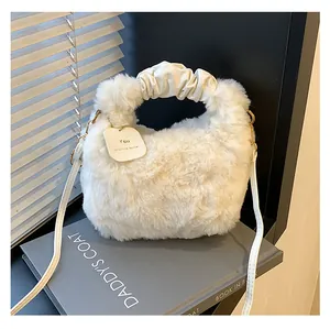 Detail einer flauschigen weißen Plüschtasche mit geriffeltem Ledergriff und Metall-D-Ring