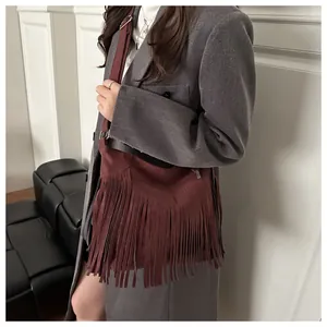 Detailed view of dark red suede tote bag with fringe tassels on model outfit