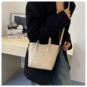 Macro view of cream vintage textured tote bag with golden hardware and fashion lettering