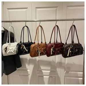 Detail of elegant shoulder bags in five colors with bow detail and beaded charms
