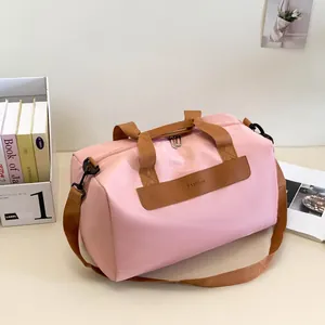 Detail of pink travel duffel bag with Fashion leather patch and adjustable strap