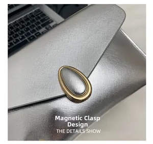 Detailed macro view of the silver envelope bag showing magnetic closure and crossgrain leather