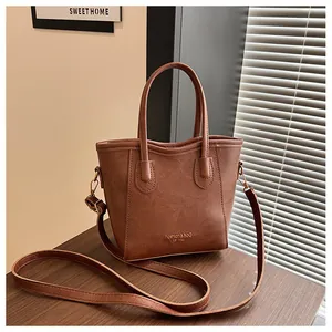 Detail of vintage brown tote bag texture with adjustable strap on wooden surface