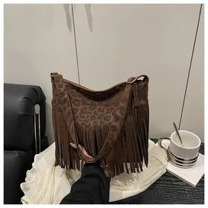 Detailed view of brown leopard print tote with suede texture and long fringe tassels