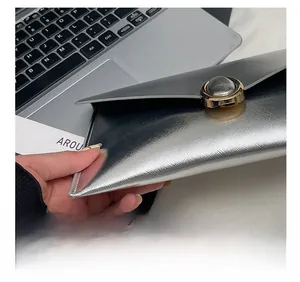 Close-up of silver envelope clutch bag with fine cross grain texture and gold metal buckle
