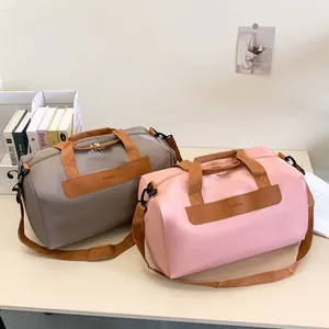 Close-up of travel bags in pink and beige featuring leather accents and dual zippers