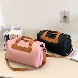 Detail view of pink and black travel bags with durable nylon fabric and fashion patch