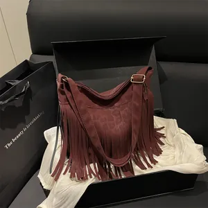 Large burgundy leopard tote bag with long fringes and golden hardware on ivory fabric