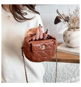 Detailopname van bruine gewatteerde PU-leren handtas met een gouden camelia-sluiting