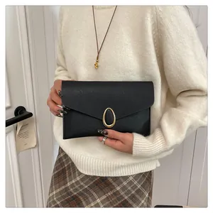 Elegant black Saffiano leather envelope clutch bag with a golden oval metal clasp