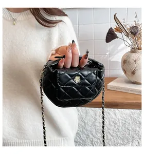 Detail van gewatteerde PU-leren handtas met gouden camellia-sluiting en ketting