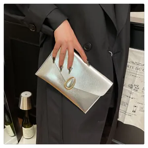 Detail of silver envelope clutch bag with premium metallic texture and gold clasp