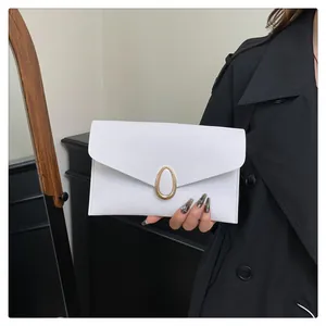 Detail of white envelope clutch bag with Saffiano texture and gold oval clasp