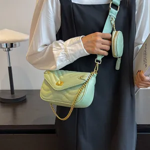 Detail of mint green quilted bag with chain, wide strap, and small coin purse attachment