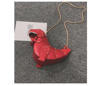 Close-up of red 3D dinosaur crossbody bag with gold rivets and metallic chain strap