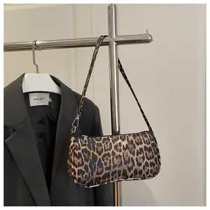 Detail van baguette-tas met luipaardprint, ritssluiting en slanke schouderriem