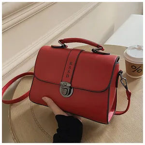 Detail van rode kunstlederen crossbodytas met handvat en verticale BSSD-reliëfband
