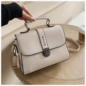Detail van gebroken witte leren tas met BSSD metalen sluiting en schouderband