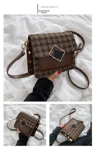 Dettaglio del tessuto pied de poule e borsa in pelle marrone con fibbia dorata e borchie