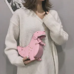 Pink dinosaur crossbody bag with gold studs and chain strap shown on model's shoulder