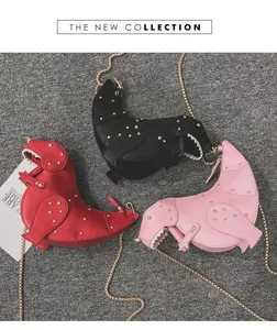 Three dinosaur cross-body bags in red black and pink with metal studs and chain straps