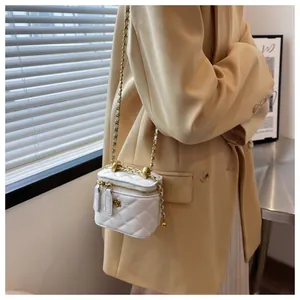 Detailed view of quilted white bag featuring gold camellia hardware and chain strap